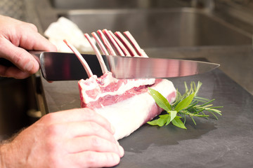 chef hands cutting lamb cutlet