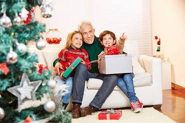Obraz na płótnie Canvas Kinder mit Opa und Geschenken zu Weihnachten