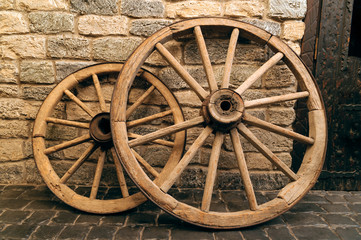 Obraz premium rustic wagon wheels in front the wall old city Baku Azerbaijan