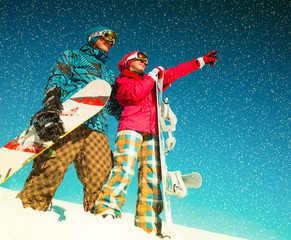 Girl and boy with snowboards on the snow