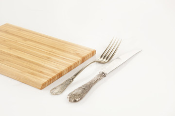Vintage fork and knife with wooden chopping board