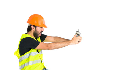 Workman holding a clock over white background