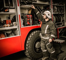 Fireman taking equipment from firefighting truck