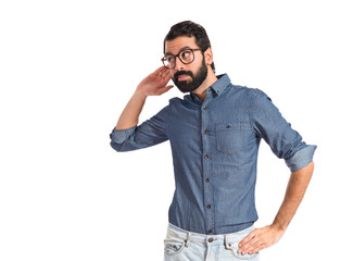 Young hipster man listening over white background