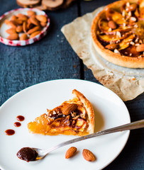 piece of apple tart on a round plate, spoon caramel