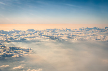 Aerial view of crispy clouds and sky from an airplane before sun