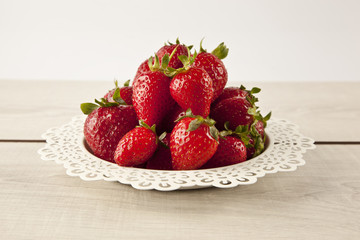 Juicy fresh ripe red strawberries on white plate