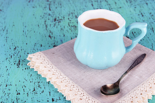 Cup of coffee with napkin on wooden table