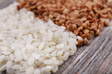 Rice and buckwheat on wooden background