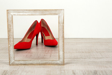 Red women shoes with frame on floor