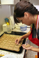 junge Frau belegt Backblech mit Hundeplätzchen