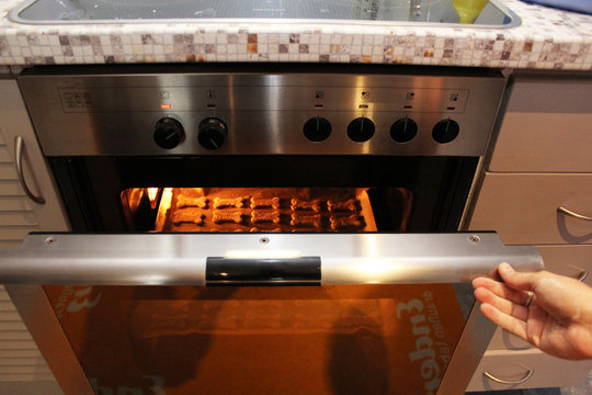 Hundepl&auml;tzchen werden in den Backofen geschoben