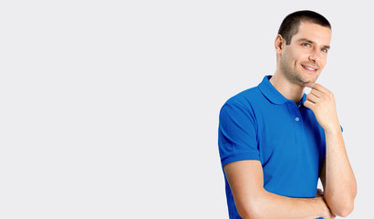 Fototapeta premium Smiling young attractive man, against grey