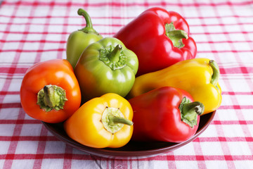 Pepper on plate on fabric background