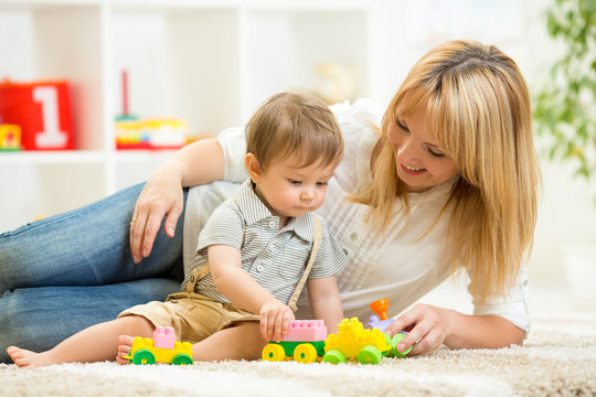 mom and kid boy playing block toys at home