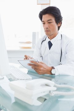 Focused doctor writing down notes