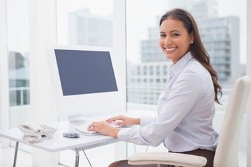 Obraz na płótnie Canvas Smiling businesswoman working at her desk