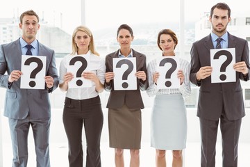 Business people holding question mark signs