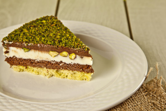 Pistachio cheesecake, mousse cake with nuts white plate