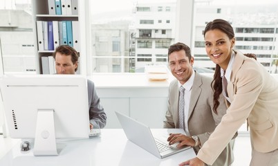Business people using laptop and computer in office