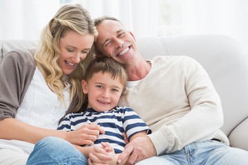 Obraz premium Happy parent tickling her cute son on the couch