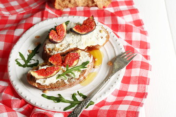 Tasty sandwiches with sweet figs and cottage cheese on plate