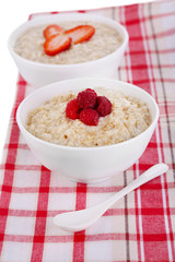 Tasty oatmeal with berries on napkin close-up