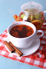 Goji berries drink in ceramic cup and cinnamon, fruit drink in