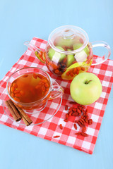 Goji berries drink in glass cup, ripe apple and cinnamon, fruit