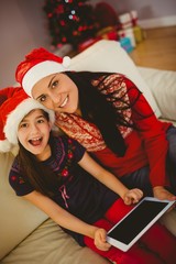 Festive mother and daughter using tablet pc