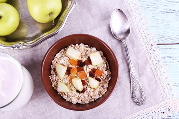 Bowl of oatmeal, dried apricots, apples and yogurt