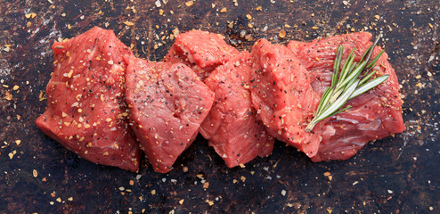 Raw beef cubes on brown rustic background - 72061471
