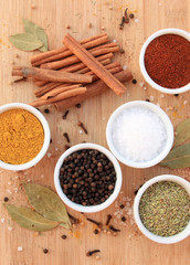 Various spices, herbs and seasonings on wooden background