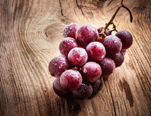 Red grape on wooden table