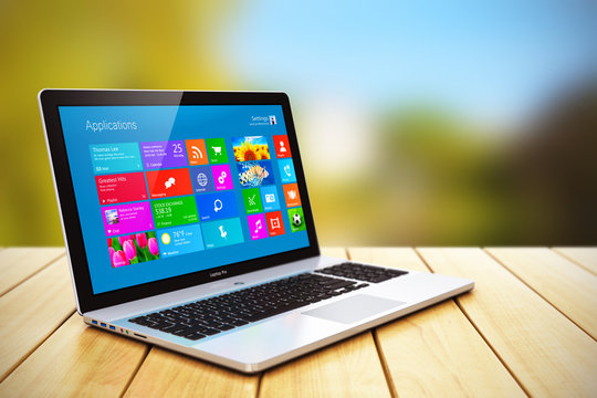 Laptop on wooden table outdoors