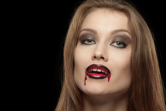Close-up portrait of a smiling gothic vampire woman