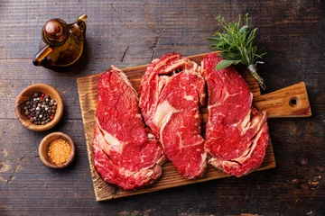 Crédence de cuisine en verre imprimé Viande Raw fresh meat Ribeye steak entrecote and seasoning on dark wood