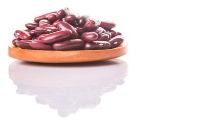 Red kidney beans on wooden spoon over white background