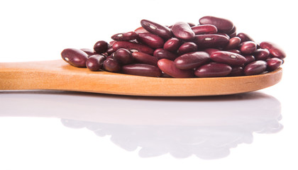 Red kidney beans on wooden spoon over white background
