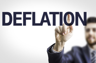 Business man pointing to transparent board with text: Deflation