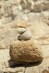 Fototapeta na wymiar Sea pebble pyramid tower on seacoast. Stone Tower