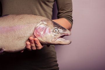 Young woman holding a rainbow trout