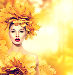 Autumn woman with yellow leaves hairstyle. Fall. Creative makeup