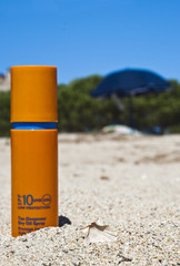 sunscreen cream on beach,seashell, trees, umbrellas and blue sky