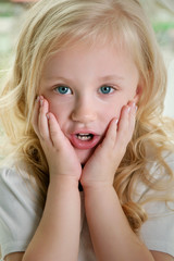 The little girl put her hands to her cheeks in surprise.