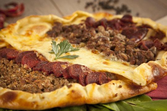 Turkish meal pizza pide stuffed with meat, cheese, pastirma