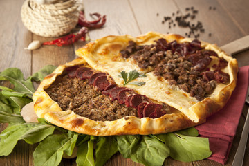 Turkish meal pizza pide stuffed with meat, cheese, pastirma