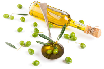 Bottle and spoon of olive oil, green olives