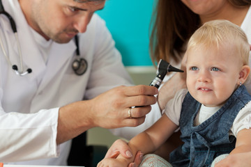 Pediatrician checking girl ears