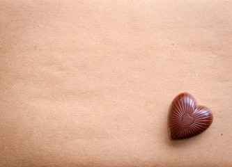 Fototapeta na wymiar Chocolate heart over old paper